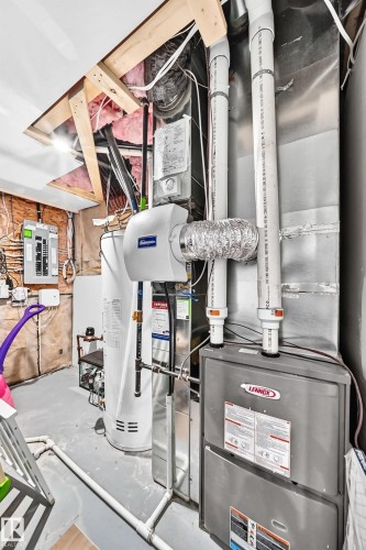 Utility area featuring a Lennox furnace, hot water heater, humidifier, and visible electrical panel - 8710 Mayday Lane, Edmonton, AB 