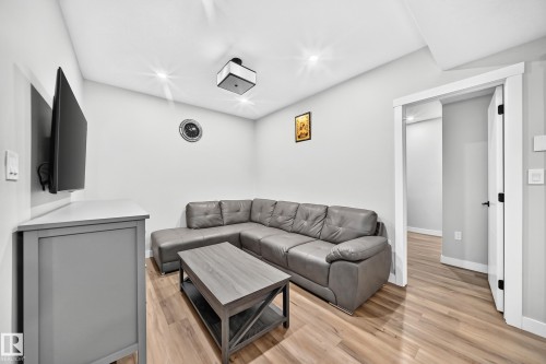 Recessed lighting illuminates this bright room featuring wood-finish flooring and a white trim doorway - 8710 Mayday Lane, Edmonton, AB 