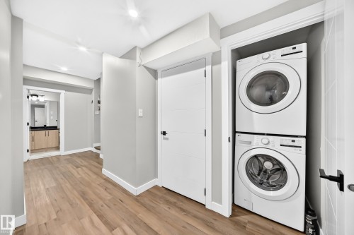 Dedicated laundry closet featuring a stacked washer and dryer - 8710 Mayday Lane, Edmonton, AB 