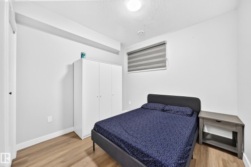 Interior room featuring wood-finish flooring, white walls, and a recessed ceiling light - 8710 Mayday Lane, Edmonton, AB 