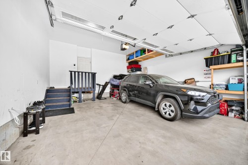 Concrete floor garage with white walls and overhead sectional door - 8710 Mayday Lane, Edmonton, AB 