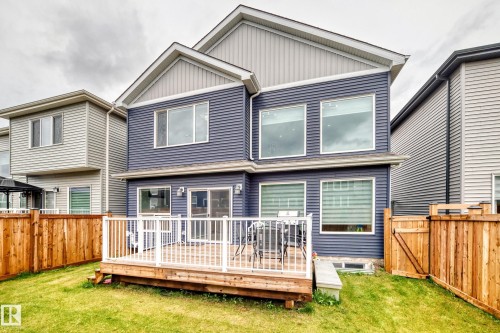 Rear exterior featuring blue horizontal siding and a light grey gable - 8710 Mayday Lane, Edmonton, AB 