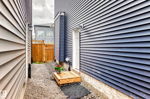 Side entryway with a wood plank step - 8710 Mayday Lane, Edmonton, AB 