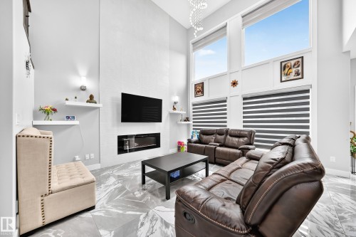 Spacious living area featuring a vaulted ceiling and large windows with integrated blinds - 8710 Mayday Lane, Edmonton, AB 
