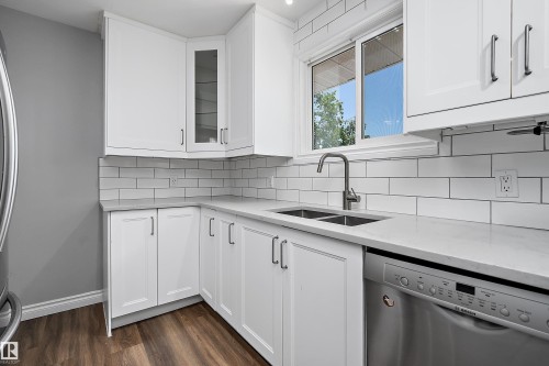 Modern kitchen featuring white shaker-style cabinetry, a stainless steel double-basin sink, and a built-in stainless steel dishwasher - 5516 47A Avenue, Wetaskiwin, AB - Indoor Photo Showing Kitchen With Double Sink