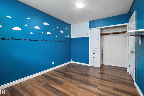 Room featuring wood-finish flooring, white baseboards, and blue painted walls - 5516 47A Avenue, Wetaskiwin, AB - Indoor Photo Showing Other Room