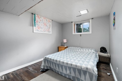 Neutral gray walls complement the wood-finish flooring - 5516 47A Avenue, Wetaskiwin, AB - Indoor Photo Showing Bedroom