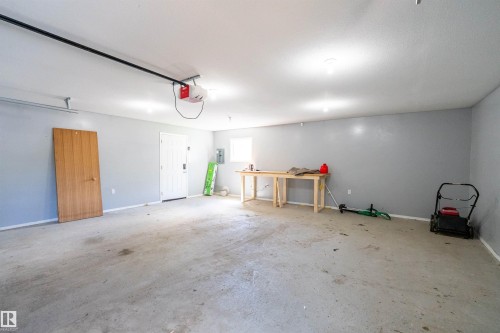 Spacious garage featuring concrete flooring, a white ceiling with recessed lighting, and light gray walls - 5516 47A Avenue, Wetaskiwin, AB - Indoor Photo Showing Garage