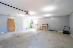 Spacious garage featuring concrete flooring, a white ceiling with recessed lighting, and light gray walls - 