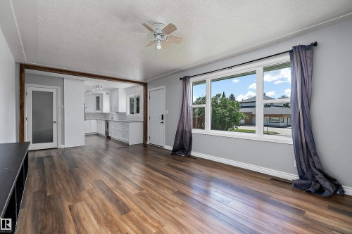 Expansive room with wood-finish flooring, a ceiling fan, and large windows - 5516 47A Avenue, Wetaskiwin, AB - Indoor Photo Showing Other Room