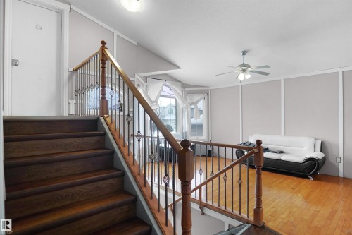 Hardwood stairs with decorative iron newel posts and wood-finish railing - 4816 155 Ave, Edmonton, AB 