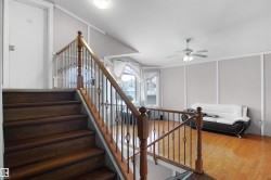 Hardwood stairs with decorative iron newel posts and wood-finish railing - 