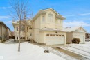 Two-story home with a two-car garage, bay window, arched window details, and a paved driveway - 4816 155 Ave, Edmonton, AB 