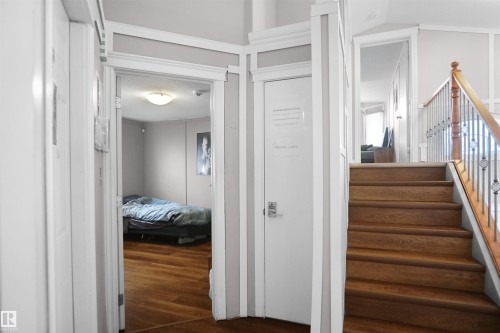 Wood-finish flooring extends from the hallway into an open room - 4816 155 Ave, Edmonton, AB 