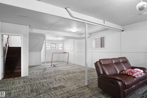 Finished basement featuring textured carpet flooring, white paneled walls, recessed lighting, and a window for natural light - 4816 155 Ave, Edmonton, AB 