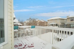 Upper-level exterior deck featuring white railing and siding - 