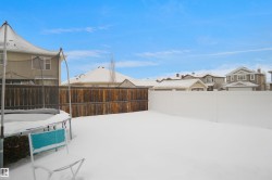 Spacious backyard featuring a wood fence and a white vinyl fence - 