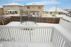 Outdoor deck with white railing, overlooking a fenced backyard - 