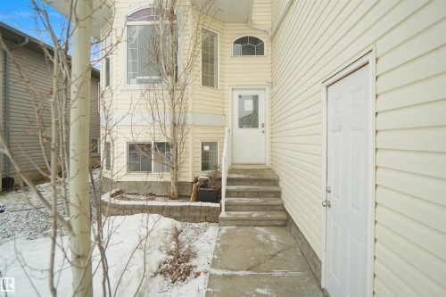 Cream-colored siding exterior featuring multiple windows, including an arched window and a large bay window - 4816 155 Ave, Edmonton, AB 