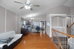 Spacious interior featuring wood-finish flooring and a vaulted ceiling - 