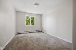 Carpeted interior room featuring light-toned walls, white trim. - 