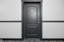 Paneled door with dark trim, featuring a door handle and deadbolt - 201 3425 19 Street Nw, Edmonton, AB 