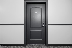 Paneled door with dark trim, featuring a door handle and deadbolt - 