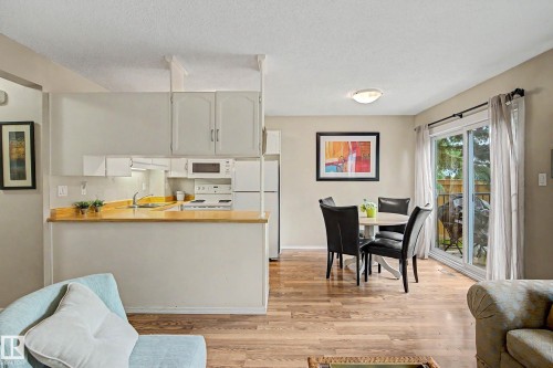 Kitchen with light cabinetry and wood-finish countertops, featuring a built-in microwave and white appliances - 19 Pineview Drive, St. Albert, AB 