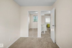 Carpeted room featuring light-colored walls and a mirrored closet - 