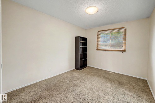 Carpeted room featuring a single window with horizontal blinds, light-colored walls, and a built-in overhead light fixture - 19 Pineview Drive, St. Albert, AB 