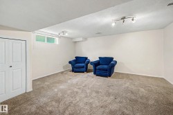 Carpeted room featuring white walls, a high-set window, and track lighting fixtures - 