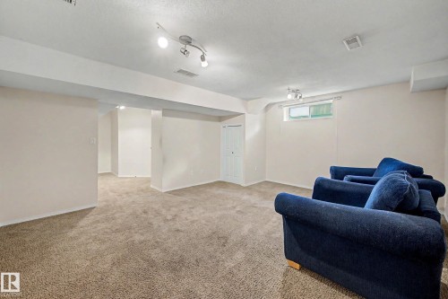Spacious carpeted room featuring white walls, a white ceiling with track lighting, and a small window - 19 Pineview Drive, St. Albert, AB 