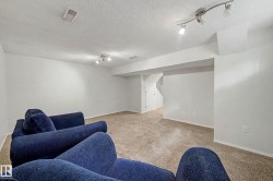 Carpeted living space featuring recessed lighting, track lighting, and white walls with base molding - 