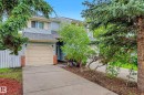 Two-story residence featuring light blue siding, a two-car garage with a panel door, and red brick accents - 19 Pineview Drive, St. Albert, AB 