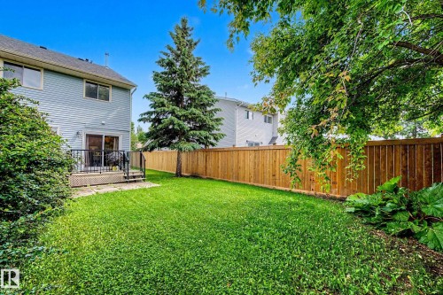 Expansive green lawn featuring a wooden privacy fence - 19 Pineview Drive, St. Albert, AB 