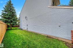 Side yard featuring a mature evergreen tree and a wood privacy fence - 