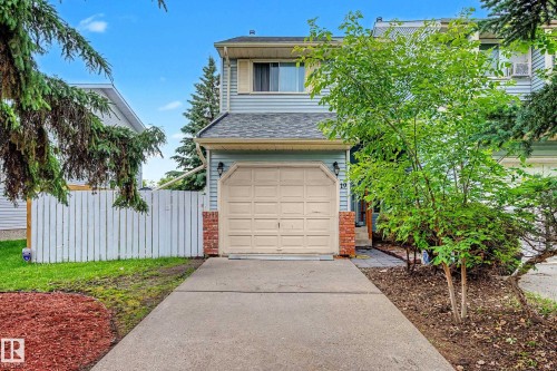 Two-story residence featuring light blue siding and a single-car garage with an overhead door - 19 Pineview Drive, St. Albert, AB 