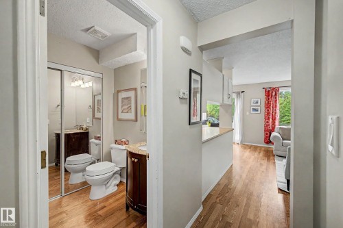 Bathroom with a dark wood vanity, light countertop, and mirrored sliding closet doors - 19 Pineview Drive, St. Albert, AB 