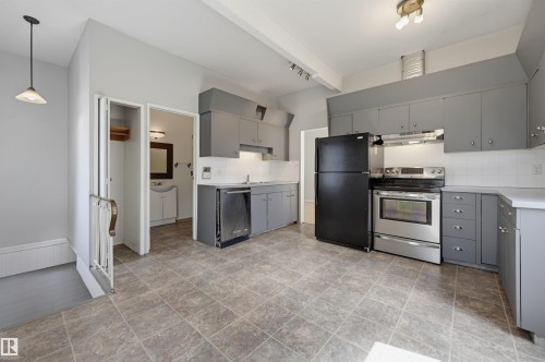 Spacious kitchen area featuring gray cabinetry, white countertops, stainless steel appliances, and tiled flooring - 11450 71 Street Nw, Edmonton, AB 