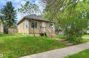 Property exterior featuring stucco siding and a front porch with wood railings - 11450 71 Street Nw, Edmonton, AB 
