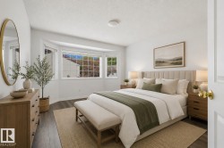 Bright bedroom featuring a large bay window, wood-finish flooring, and a neutral color palette - 