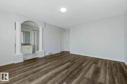 Spacious room featuring wood-finish flooring and light gray walls - 