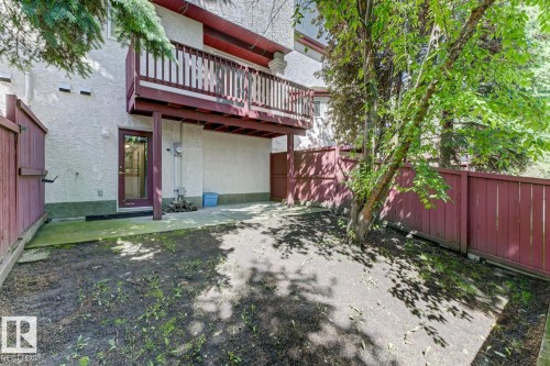 Private fenced yard featuring a concrete patio area, mature trees, and direct access to the lower level - 6 1237 Carter Crest Road, Edmonton, AB 