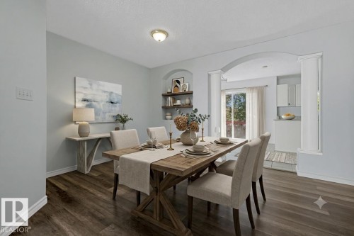 Dining area featuring wood-finish flooring, a contemporary ceiling light fixture, and light blue wall tones - 6 1237 Carter Crest Road, Edmonton, AB 