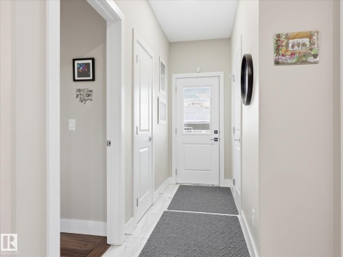 Entryway featuring a white paneled door with a frosted glass insert, neutral wall tones, white trim, and light-colored flooring - 12820 68 Street, Edmonton, AB - Indoor Photo Showing Other Room
