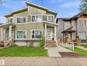 Contemporary exterior featuring a split-level roofline and light green siding - 12820 68 Street, Edmonton, AB  - Outdoor With Facade 