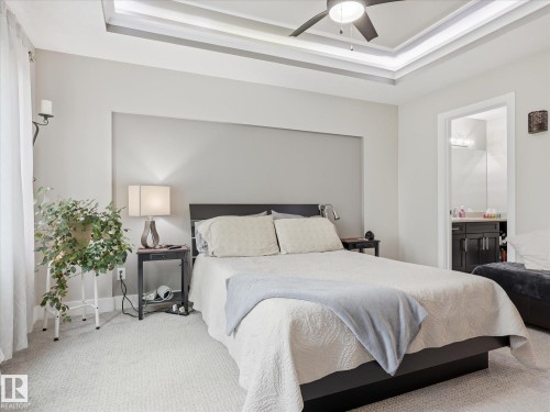 Bedroom featuring a tray ceiling with integrated lighting, a ceiling fan, and light-colored carpeting - 12820 68 Street, Edmonton, AB - Indoor Photo Showing Bedroom