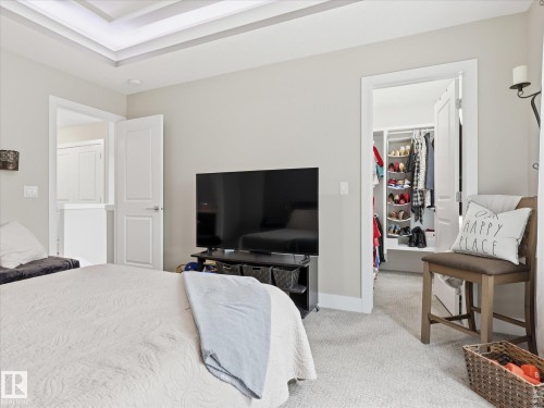Bedroom featuring a tray ceiling with accent lighting, light gray wall paint, and plush carpet flooring - 12820 68 Street, Edmonton, AB - Indoor Photo Showing Bedroom