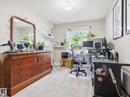 Carpeted interior space featuring a window with natural light, a ceiling-mounted light fixture, and light-colored walls - 12820 68 Street, Edmonton, AB - Indoor Photo Showing Office