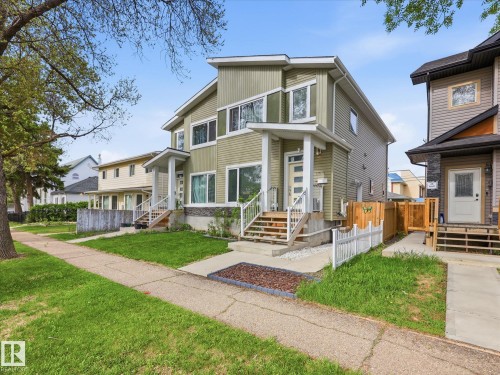 Modern two-story duplex with a distinct architectural design, featuring a light green siding exterior - 12820 68 Street, Edmonton, AB - Outdoor